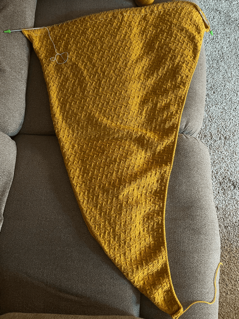 A yellow-squash colored shawl with a crosshatch pattern