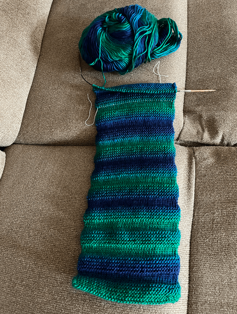A partially-knit scarf in blue and green jewel tones