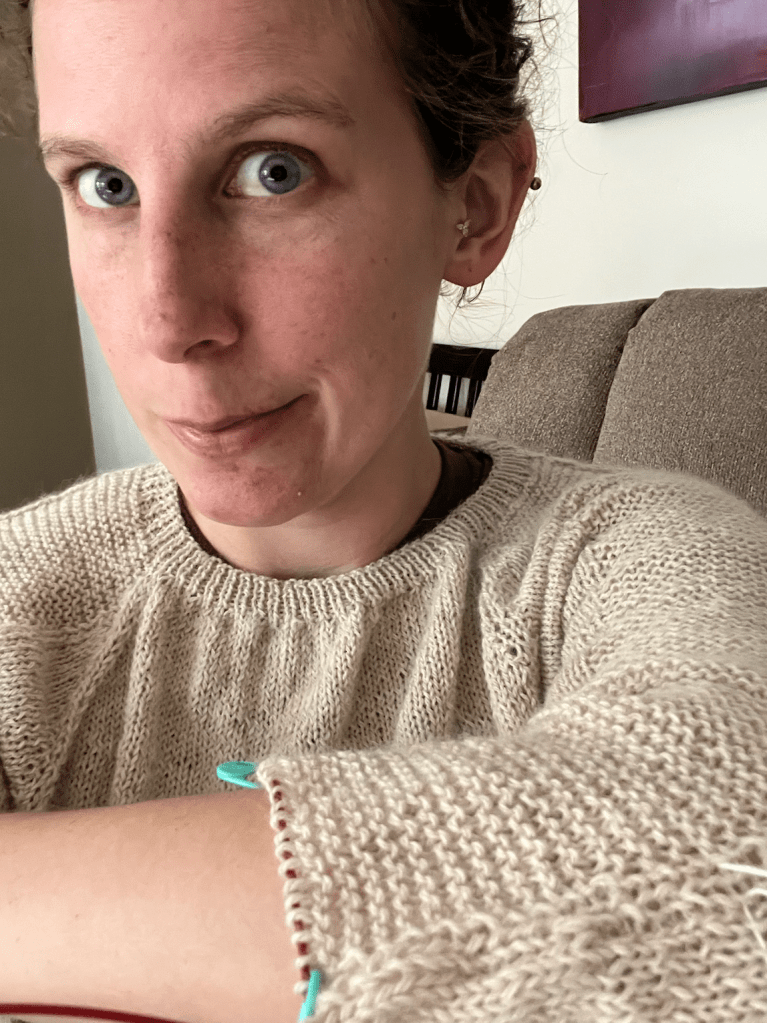 Author wearing partially-completed knit sweater