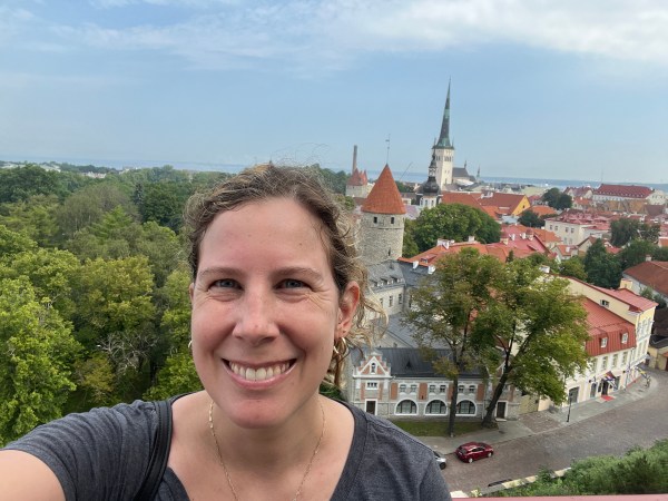 Kaitlyn is standing on an overlook with the medieval city of Old Tallinn spread out behind her
